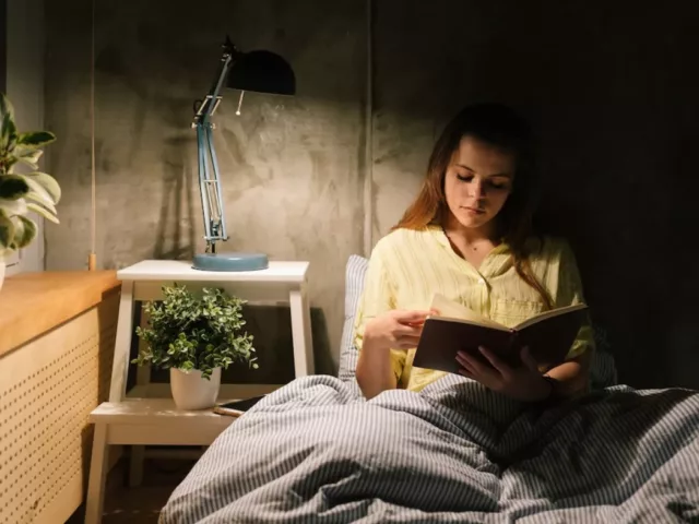 Woman reading in bed as part of her bedtime routine