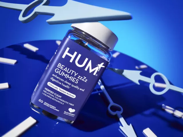 HUM Beauty zzZz Gummies for sleep and digestion, with a clock in background