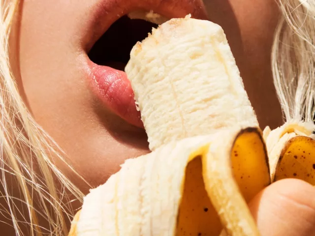 Woman eating a banana, a great food with prebiotics