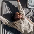 Happy woman stretching in bed after getting beauty sleep