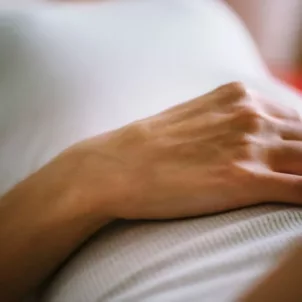 woman with hand on stomach due to bloated stomach