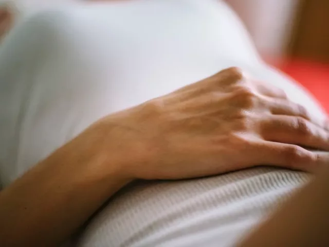 woman with hand on stomach due to bloated stomach