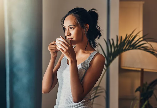 Mujer bebiendo café mientras ayuna intermitentemente para apoyar la pérdida de peso