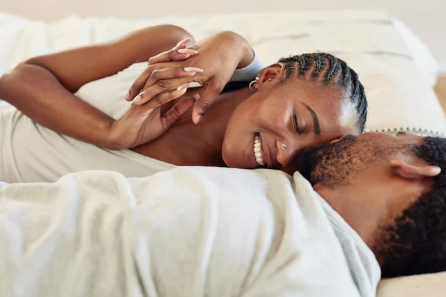Pareja en la cama experimentando mayor intimidad durante el sexo menstrual