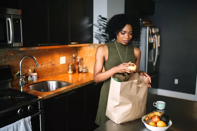 Woman unbagging healthy groceries