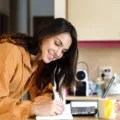 Woman planning her meals in kitchen as she counts macros for weight loss