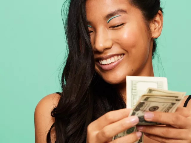 Woman counting money for financial wellness concept