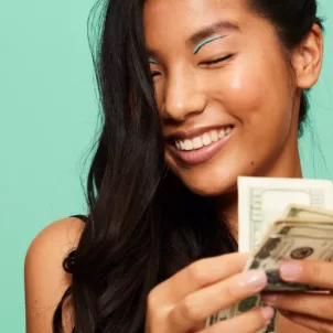 Woman counting money for financial wellness concept