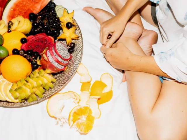 Woman eating fruit in bed