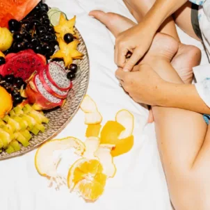 Woman eating fruit in bed