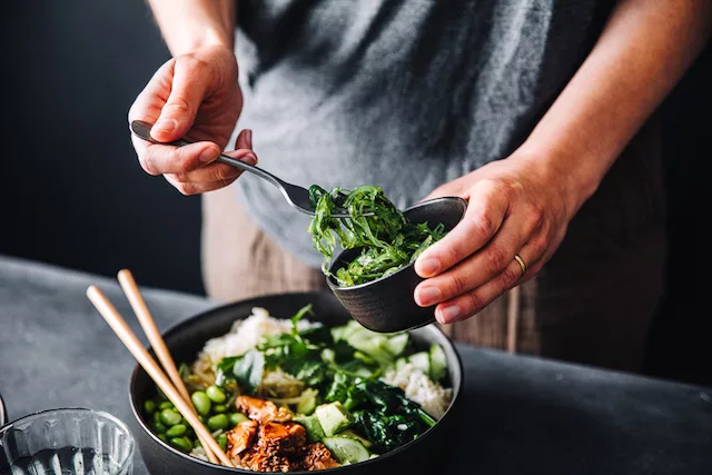 Mujer preparando una comida saludable con macros y micronutrientes para promover la pérdida de peso