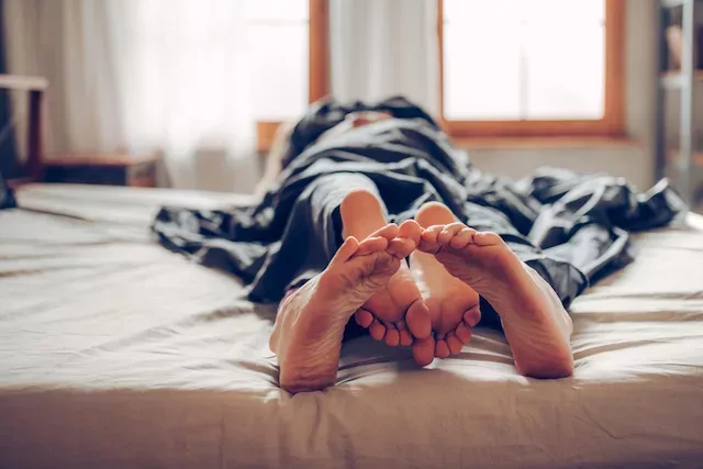 Couple's feet in bed