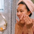 Woman applying acne spot treatments in mirror