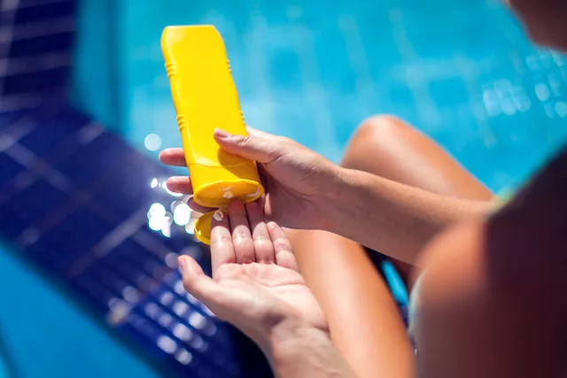 Woman applying SPF 30 from Target while lounging by the pool in summer