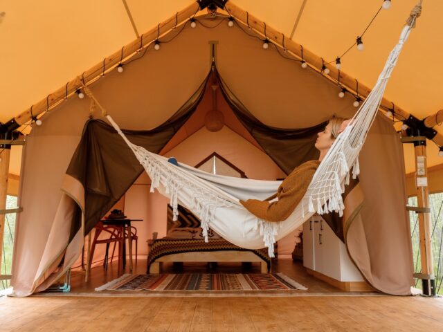 Woman relaxing in a hammock and enjoying a wellness routine while on vacation