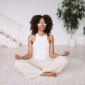 Woman meditating with eye masks and practicing simple self-care at home