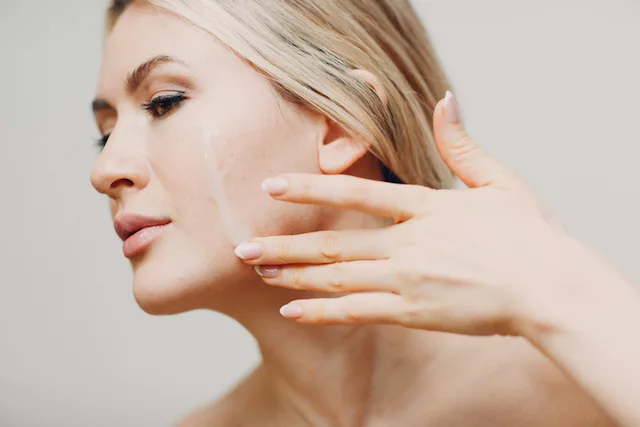 Dry and patchy skin. Woman moisturizing her skin.